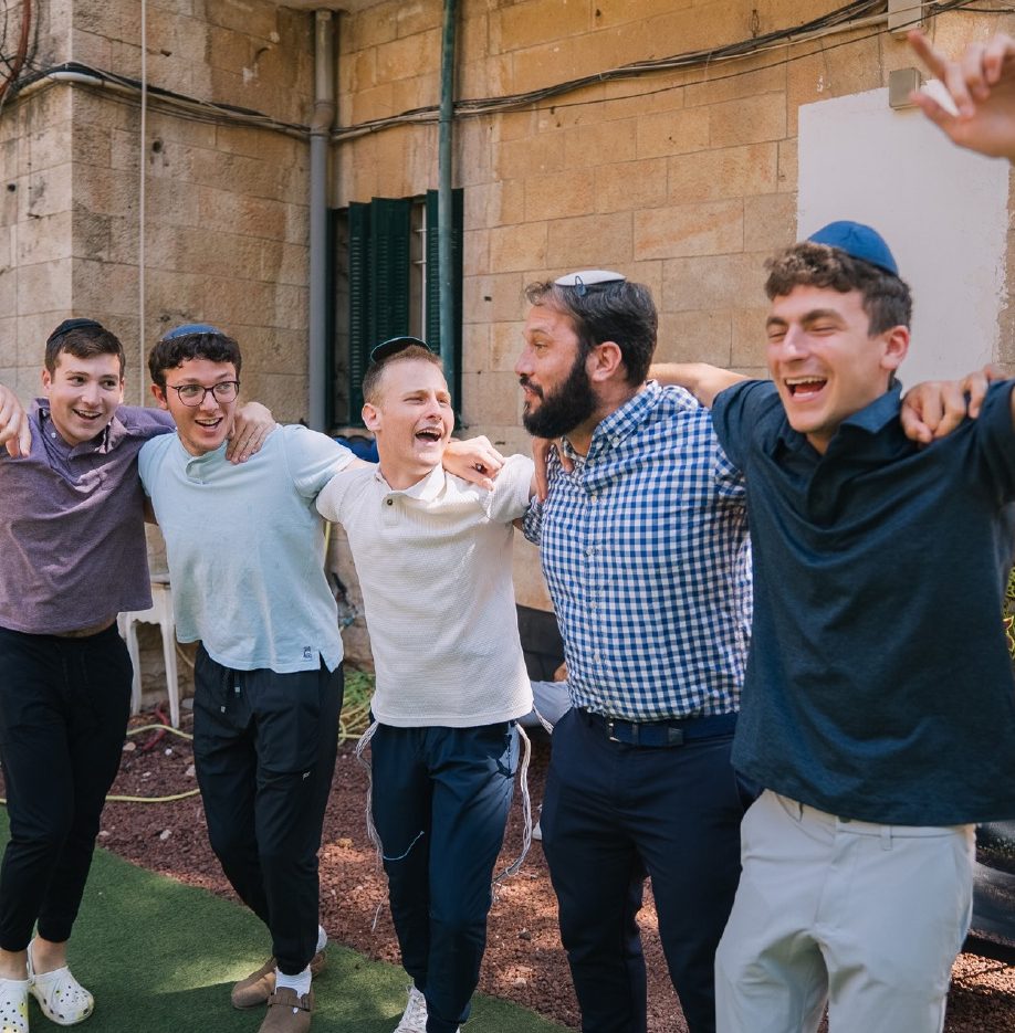 Four talmidim and a Rebbe, arms around each other, singing