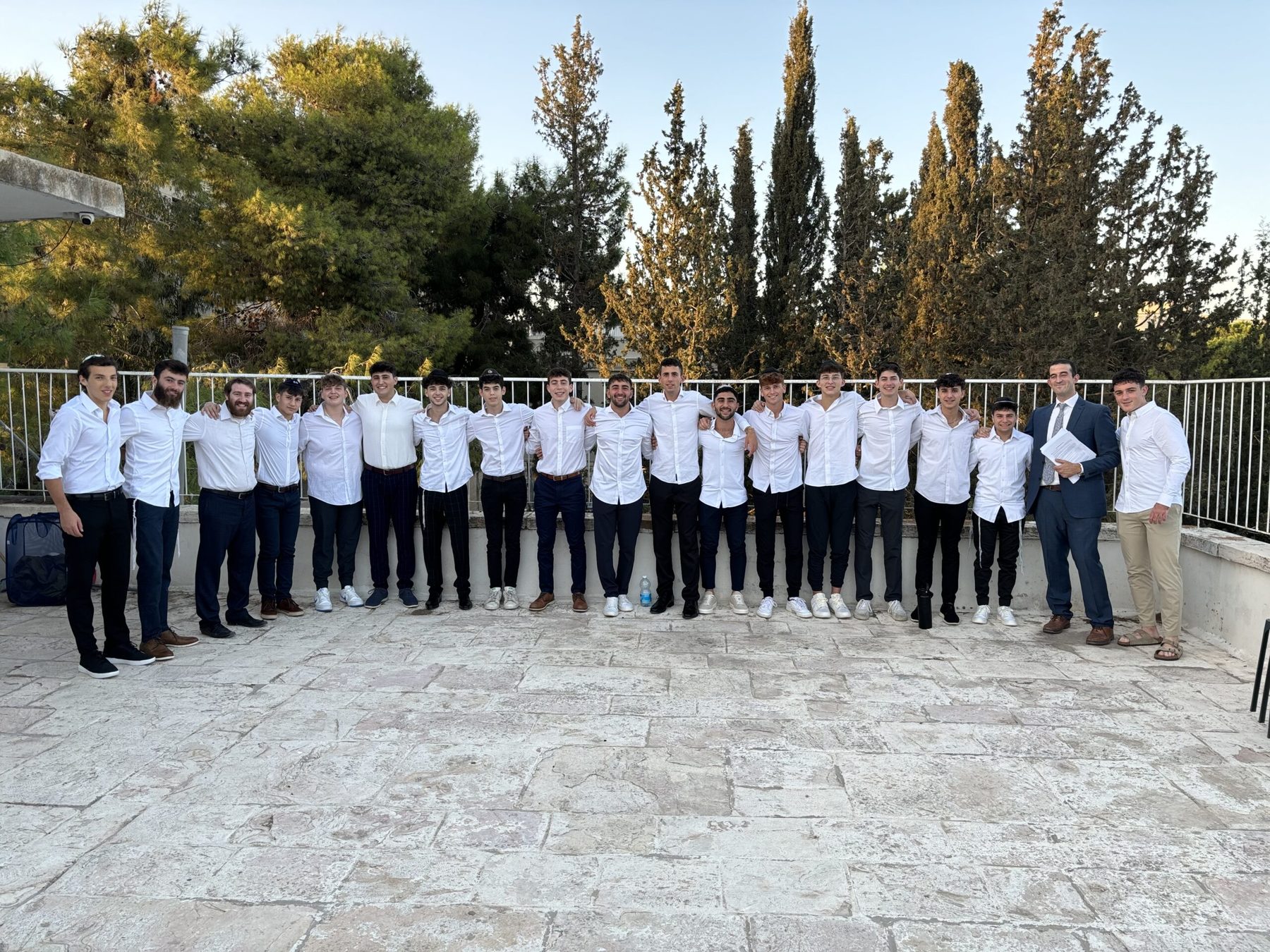 Two talmidim in chavruta across a table stacked with sefarim